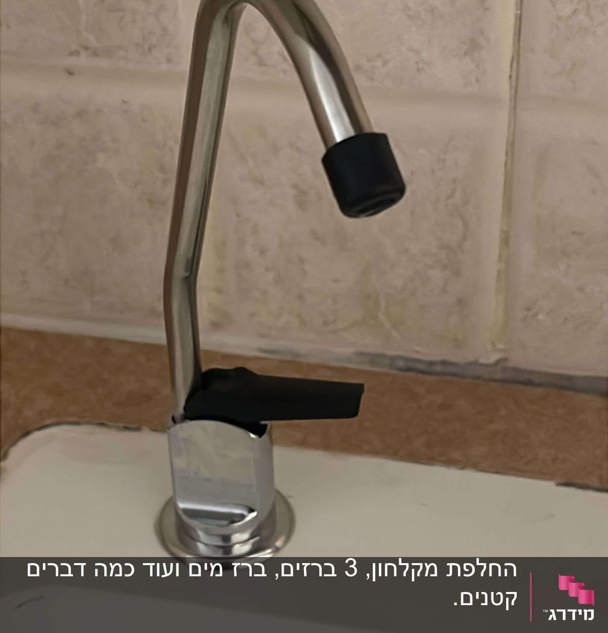 ברז מתכת עם ידית שחורה על כיור לבן